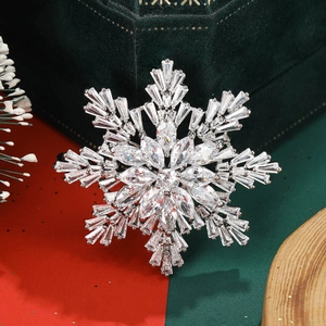 Détail macro de broche flocon de neige en zircon sur fond de boîte cadeau en velours vert
