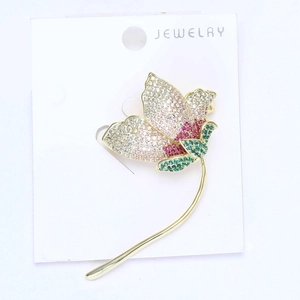 Macro detail of micro-paved gradient zircon flower brooch with fine golden metal finish