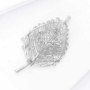 Detailed back view of silver leaf brooch showing safety pin and hollow texture