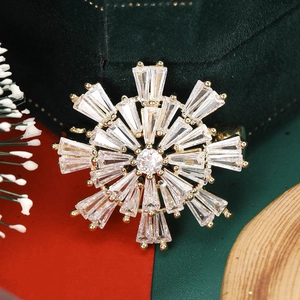 Macro shot of snowflake brooch with gold metal base and cubic zirconia stones