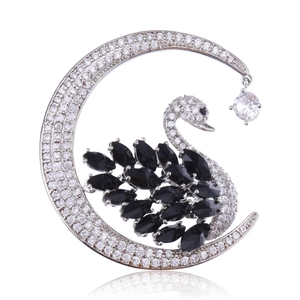 Detailed macro view of black swan crescent moon brooch with sparkling crystals and silver base