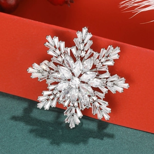 Détail d'une élégante broche flocon de neige en zircone sur un coffret cadeau rouge