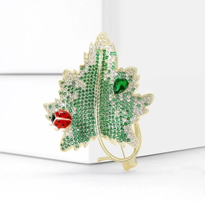 Elegant gold-plated maple leaf brooch with green zircons and a small red ladybug accent