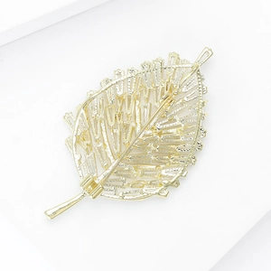 Detailed back view of a gold leaf brooch with intricate filigree and secure pin clasp