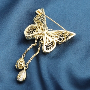 Elegant gold butterfly brooch with hollow filigree, zircon inlay, and hanging tassels
