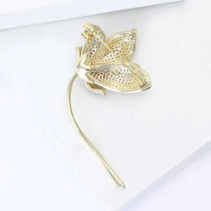 Macro detail of gold flower brooch back with honeycomb hollow design and pin clasp