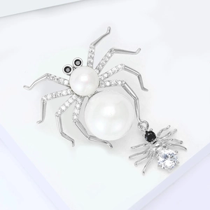 Macro detail of silver spider brooch with white pearls and micro-set zircon stones
