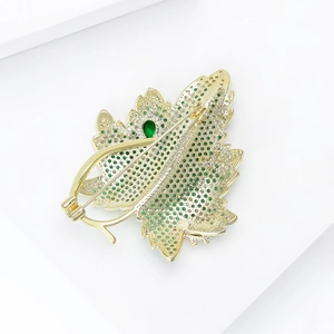 Detailed macro view of the gold-plated maple leaf brooch showing a secure rotating pin clasp
