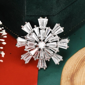 Detailed close-up of a silver snowflake brooch with baguette and round cut zircons