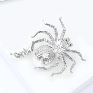 Detailed close-up showing the secure metal pin fastener on the spider brooch back