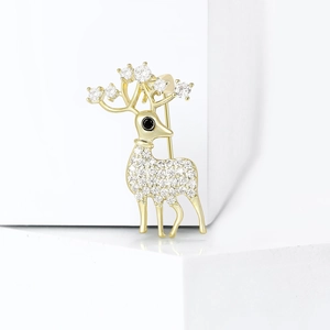 Broche renne dorée ornée de zircons blancs étincelants sur fond minimaliste blanc