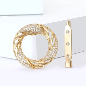 Elegant gold spiral silk scarf clip with sparkling zircons on white pedestal