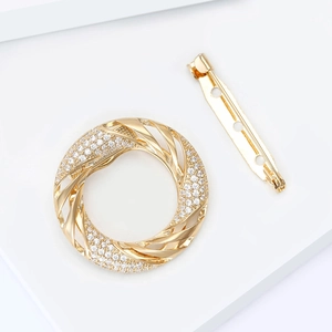 Elegant gold round scarf buckle with micro-pave cubic zirconia on a white pedestal