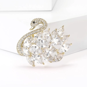 Elegante broche de cisne dorado con circonitas micro-pavé en soporte geométrico blanco