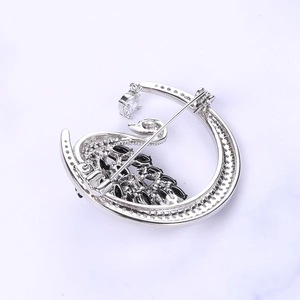 Detail view of the silver swan moon brooch back with a secure safety pin fastener