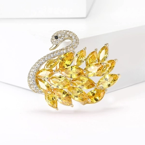 Detalle macro de broche de cisne con circonitas amarillas y cristales pavé finos