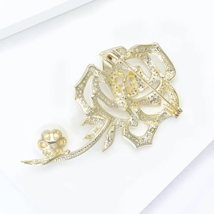 Détails de l'élégante broche rose dorée avec micro-diamants pavés et perle blanche ronde