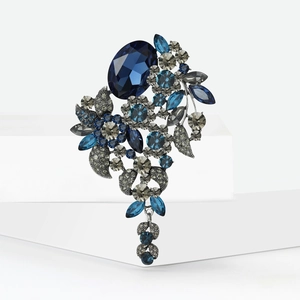 Detailopname van luxe kristallen broche met blauwe stenen en zilveren kwastjes