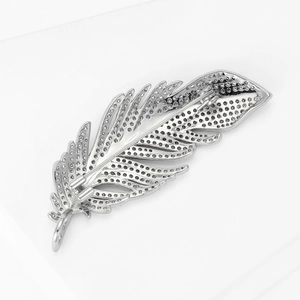 Vue arrière détaillée d'une broche plume montrant le fermoir et le métal ajouré
