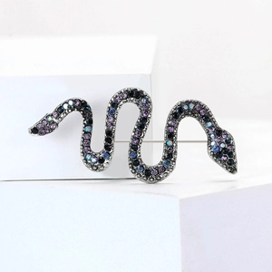 Detail of snake brooch with gradient rhinestones on minimalist geometric blocks