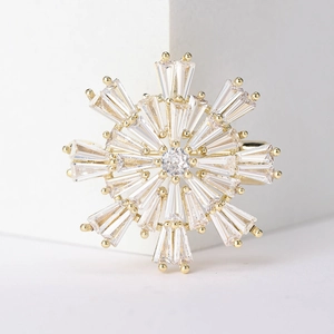 Macro detail of snowflake brooch with pavé set cubic zirconia and golden metallic base