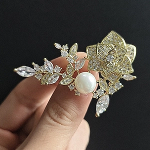 Détail d'une broche en rose plaqué or avec zircons et incrustation de perles
