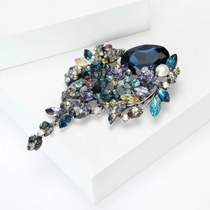 Macro detail van luxe kristallen broche met donkerblauwe steen en kwastjes