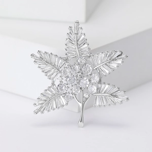 Exquisite silver-toned leaf brooch featuring micro-pave zircons and star-shaped design