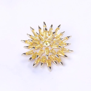 Detailed macro view of the yellow zircon snowflake brooch with starburst metal design