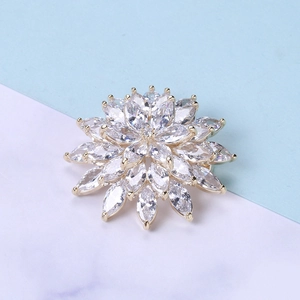 Macro detail of snowflake zircon brooch with marquise cut stones and golden plating