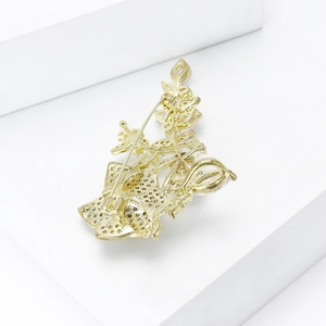 Détails de l'arrière d'une broche rose dorée avec une monture ajourée et une épingle solide