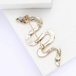Detail view showing the golden back structure and secure safety pin of the snake brooch