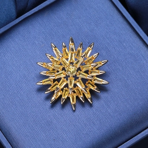 Detail of starburst brooch featuring yellow zircon stones and silver-tone claw setting