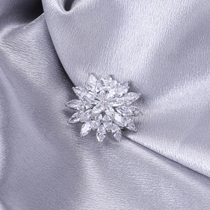 Macro detail of silver snowflake brooch with marquise cut cubic zirconia petals