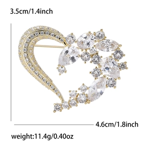 Elegante spilla a cuore dorata con zirconi luccicanti, dimensioni 3,5cm x 4,6cm fondo bianco