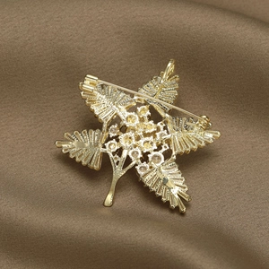 Back view of a gold maple leaf brooch with sparkling zircons and secure pin clasp closure