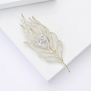 Detailed view of elegant gold feather brooch with micro-pave cubic zirconia crystals