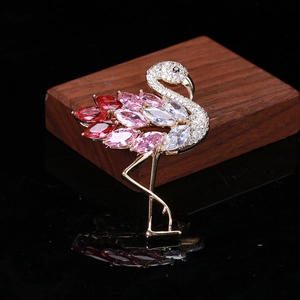 Detailansicht der Flamingo-Brosche mit bunten Zirkonia-Steinen auf dunklem Holz