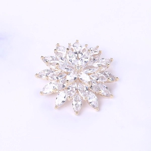 Detailed macro view of zircon snowflake brooch with gold metal petals and marquise-cut stones