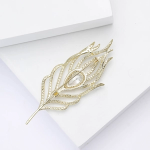 Elegant gold feather brooch with hollow design and teardrop cubic zirconia inlay