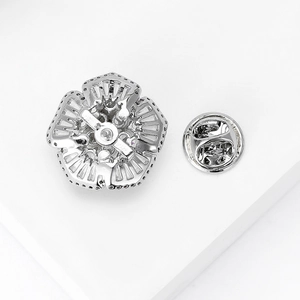 Minimalist silver flower brooch with zircon inlay showing back pin and butterfly clasp