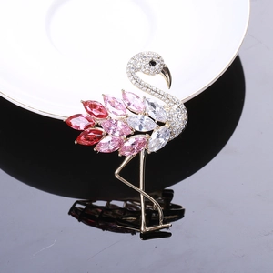 Detail der Flamingobrosche mit roten und rosa Zirkoniasteinen in goldener Metallfassung