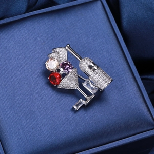 Macro detail of wine bottle brooch with micro-pave zircons and colorful main stones