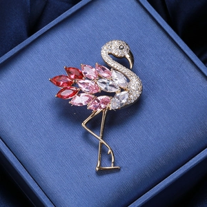 Makroaufnahme einer Flamingo-Brosche mit roten Zirkoniasteinen auf einer blauen Box