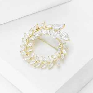 Makroaufnahme der goldenen Olivenzweig-Brosche mit Marquise-Zirkonia-Kristallen