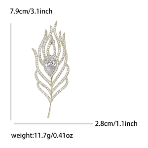Elegant gold feather brooch with micro-pave cubic zirconia and drop-shaped crystal stone