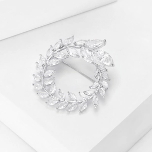 Makro-Detail der silbernen Olivenzweig-Brosche mit marquise-geschliffenen Zirkonsteinen