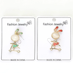Close-up of cute rabbit scooter brooches with opal stones and sparkling rhinestones