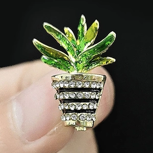Detailed macro view of a green enamel cactus brooch with sparkling zircon inlays