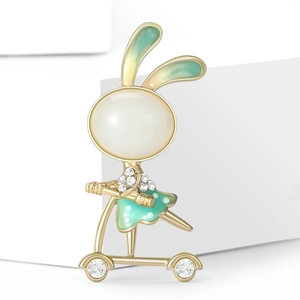 Detailed view of rabbit brooch with white pearl head and green enamel scooter decoration